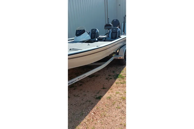 Slide: The Image of 2025 Ranger ALPHA 208 boat on trailer, parked outdoors near a metal building. - 20