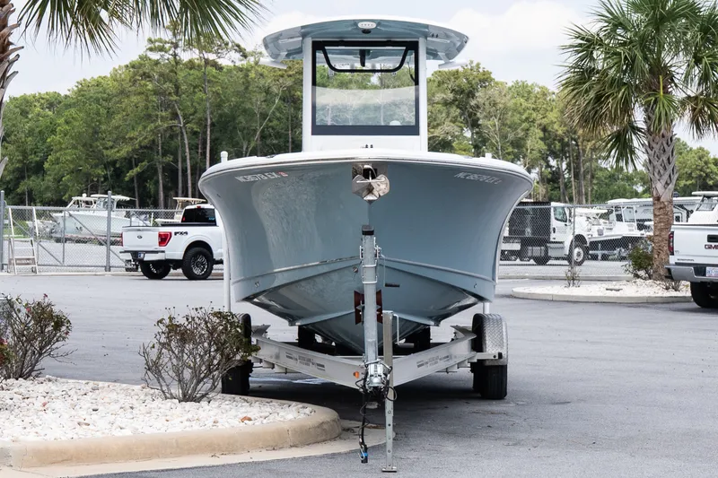 Slide: The Image of 2022 Sea Hunt Ultra 265SE boat on trailer in parking lot, surrounded by trees and vehicles. - 3