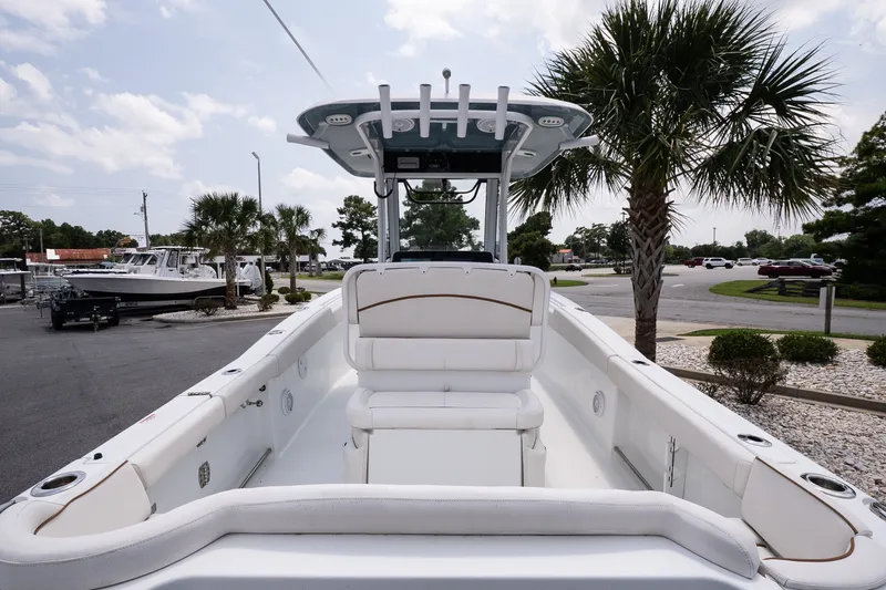 Slide: The Image of 2022 Sea Hunt Ultra 265SE boat interior with seating, palm trees in the background. - 7