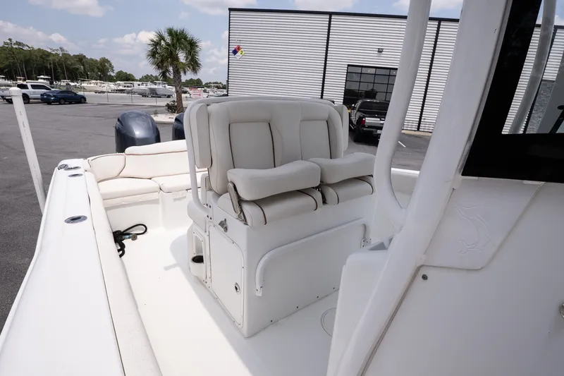 Slide: The Image of 2022 Sea Hunt Ultra 265SE boat interior with cushioned seating and dual engines. - 13