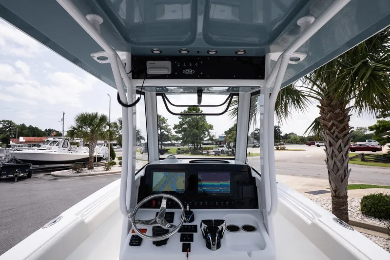 Slide: The Image of 2022 Sea Hunt Ultra 265SE boat dashboard with steering wheel and navigation display. - 9