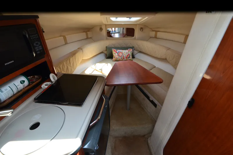 Slide: The Image of 2007 Sea Ray 240 Sundancer cabin interior with seating, table, and kitchenette. - 11