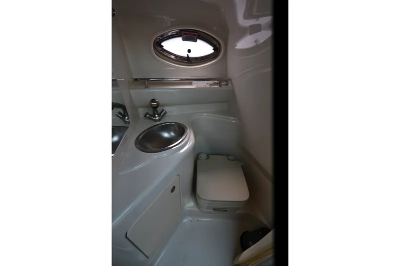 Slide: The Image of 2007 Sea Ray 240 Sundancer boat bathroom with sink, toilet, and porthole window. - 14