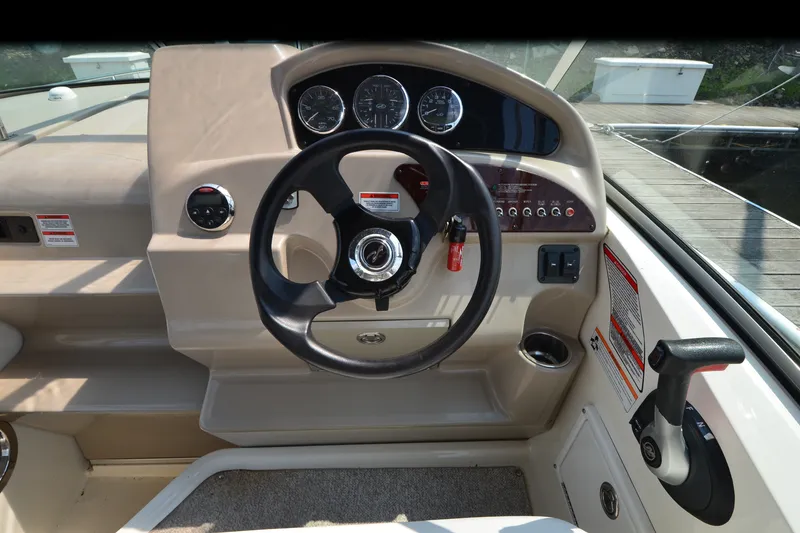 Slide: The Image of Steering console of a 2007 Sea Ray 240 Sundancer boat, featuring gauges and controls. - 6