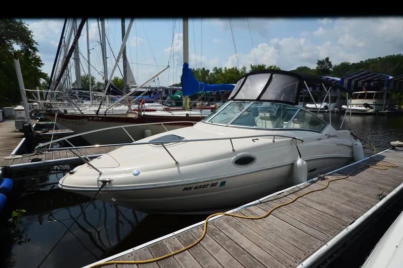 The Image of 2007 Sea Ray 240 Sundancer docked at marina, surrounded by sailboats and calm water. - 0