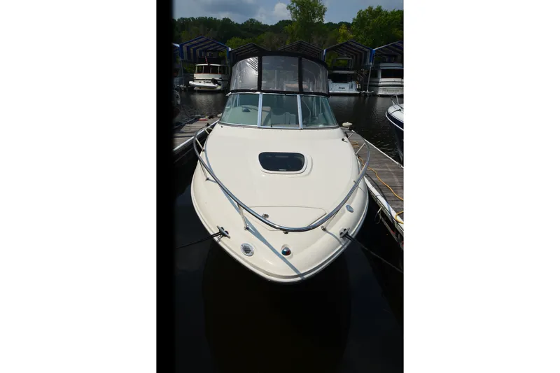 Slide: The Image of 2007 Sea Ray 240 Sundancer docked at marina, front view with canopy. - 2