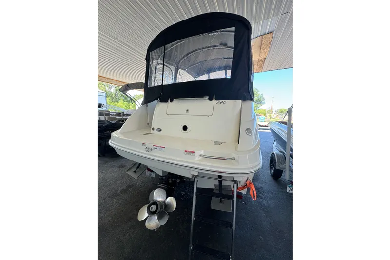 Slide: The Image of 2007 Sea Ray 240 Sundancer boat, rear view under shelter, showcasing propeller and canopy. - 19