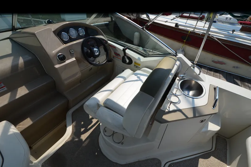 Slide: The Image of 2007 Sea Ray 240 Sundancer cockpit with steering wheel, gauges, and sink. - 7
