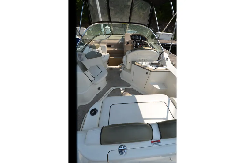 Slide: The Image of 2007 Sea Ray 240 Sundancer boat interior with seating and helm, featuring a sleek design. - 4
