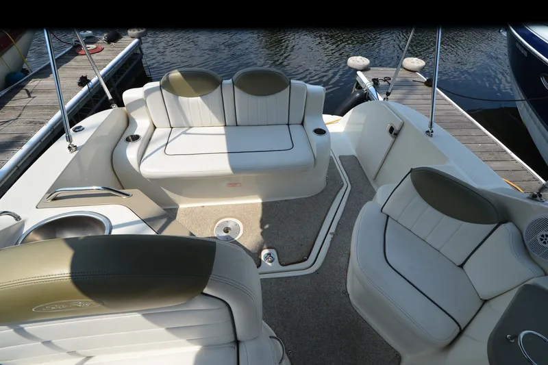 Slide: The Image of 2007 Sea Ray 240 Sundancer boat interior with white seating and dock view. - 8