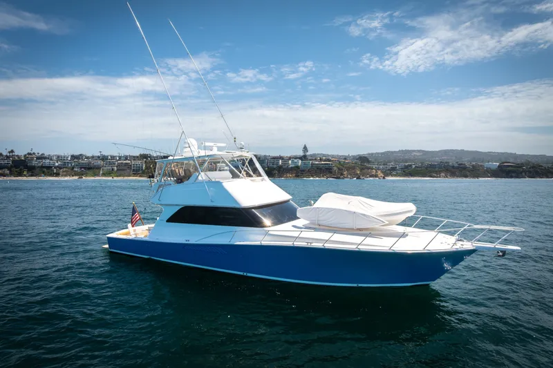 The Image of 2001 Viking 55 Convertible yacht on open water, with coastal background and clear skies. - 0