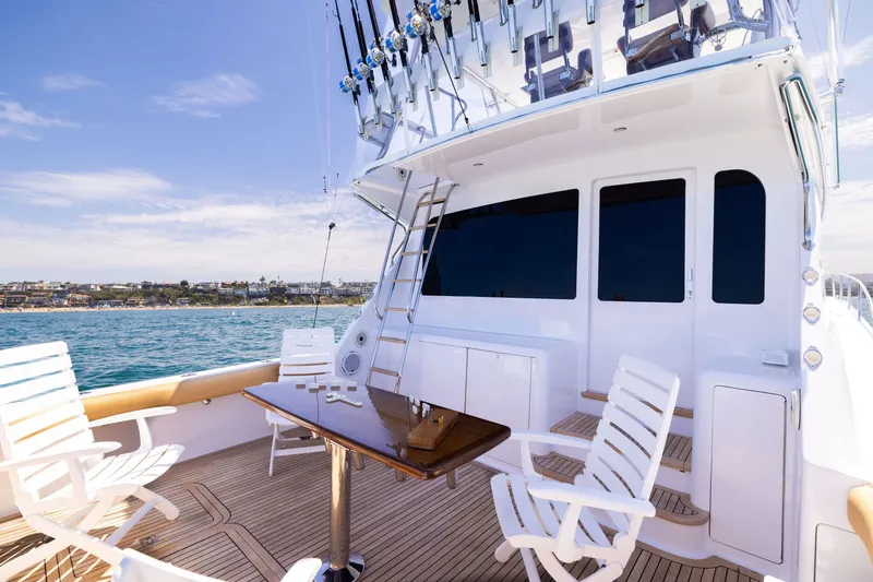 Slide: The Image of 2001 Viking 55 Convertible yacht deck with chairs and table, overlooking ocean and coastline. - 5