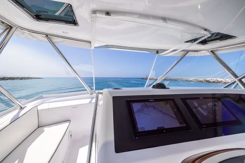 Slide: The Image of Cockpit view of 2001 Viking 55 Convertible yacht with navigation screens and ocean scenery. - 18