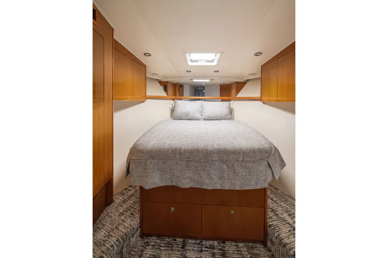Slide: The Image of Interior cabin of 2001 Viking 55 Convertible yacht with cozy bed and wooden cabinetry. - 4
