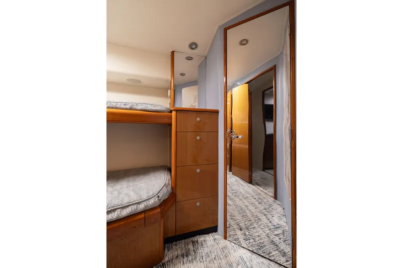 Slide: The Image of Interior of 2001 Viking 55 Convertible yacht with bunk beds and mirrored door. - 56