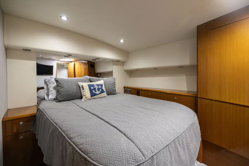 Slide: The Image of Luxurious bedroom interior of 2001 Viking 55 Convertible yacht with elegant bedding and wood cabinetry. - 40