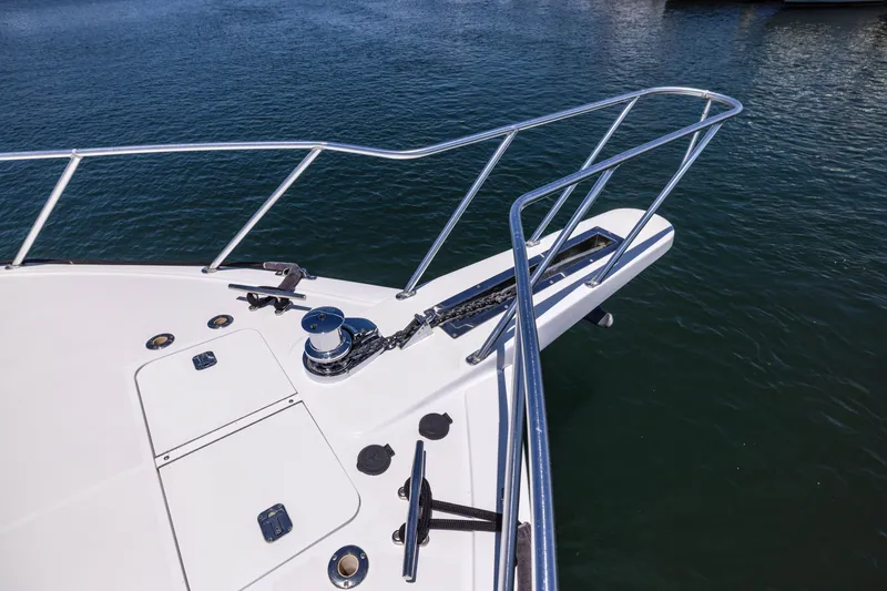 Slide: The Image of Bow of 2001 Viking 55 Convertible yacht with anchor and railing over water. - 28
