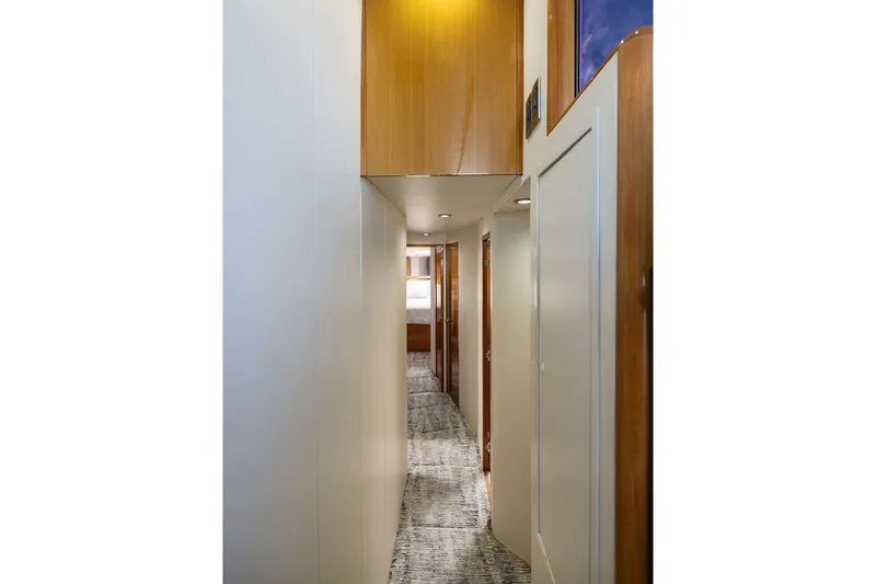 Slide: The Image of Hallway interior of 2001 Viking 55 Convertible yacht with wood accents and carpet flooring. - 53