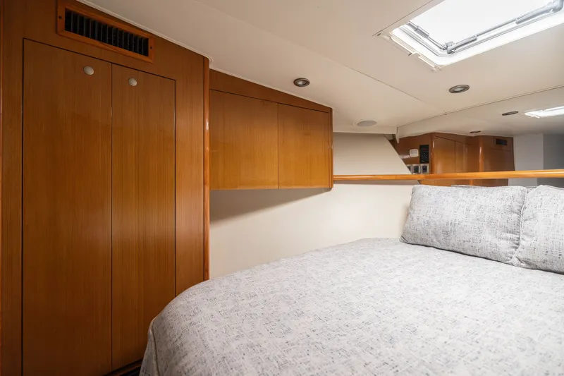 Slide: The Image of Interior cabin of 2001 Viking 55 Convertible yacht with wooden cabinets and cozy bedding. - 51