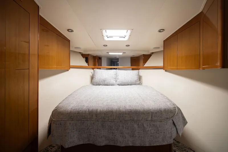Slide: The Image of Luxurious cabin interior of 2001 Viking 55 Convertible yacht with cozy bed and wooden cabinetry. - 50