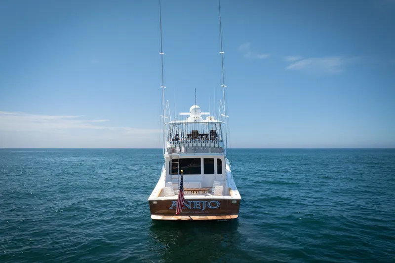 Slide: The Image of 2001 Viking 55 Convertible yacht on open sea under clear blue sky. - 63