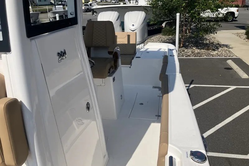 Slide: The Image of 2027 Caymas 291 boat interior with beige seating and sleek white design. - 11