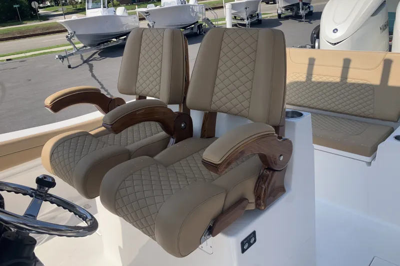 Slide: The Image of Luxury seating on 2027 Caymas 291 boat, featuring quilted upholstery and wooden armrests. - 18