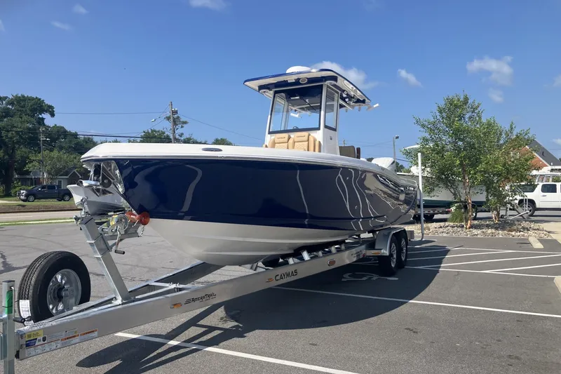 Slide: The Image of 2027 Caymas 291 boat on trailer in parking lot under clear blue sky. - 7