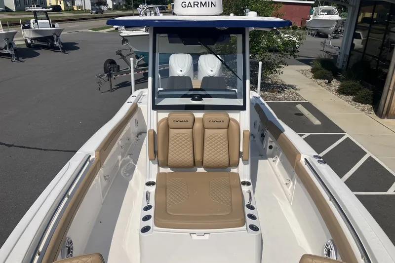 Slide: The Image of 2027 Caymas 291 boat with tan seating and Garmin navigation system in a marina setting. - 14