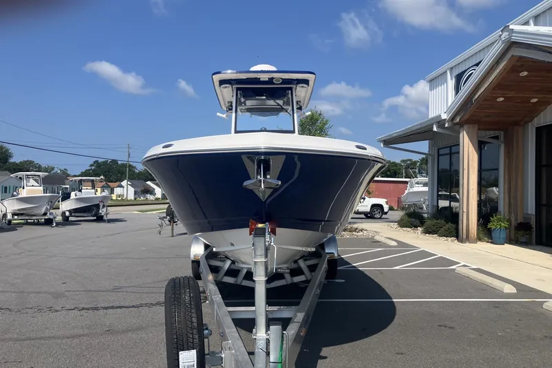 Slide: The Image of 2027 Caymas 291 boat on trailer outside dealership under blue sky. - 9