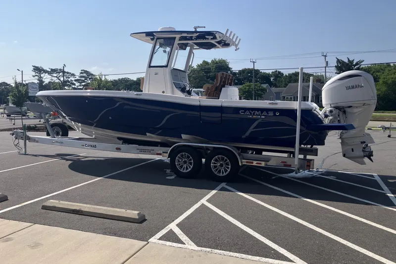 Slide: The Image of 2027 Caymas 291 boat on trailer in parking lot, featuring Yamaha engine. - 6