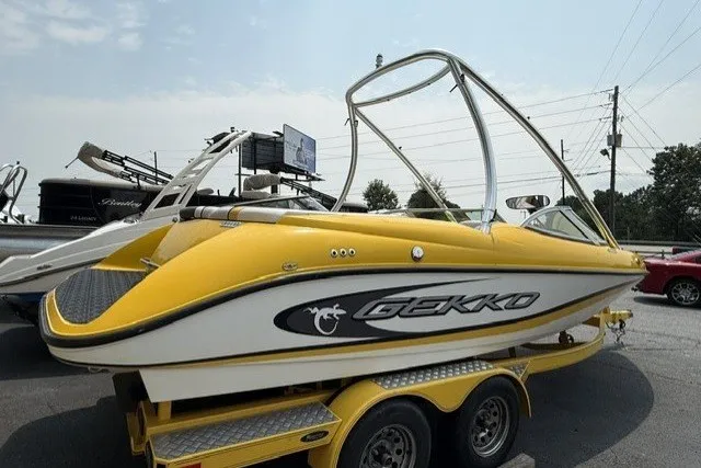 Slide: The Image of Yellow 2009 Gekko Revo boat on trailer, parked outdoors under a clear sky. - 2