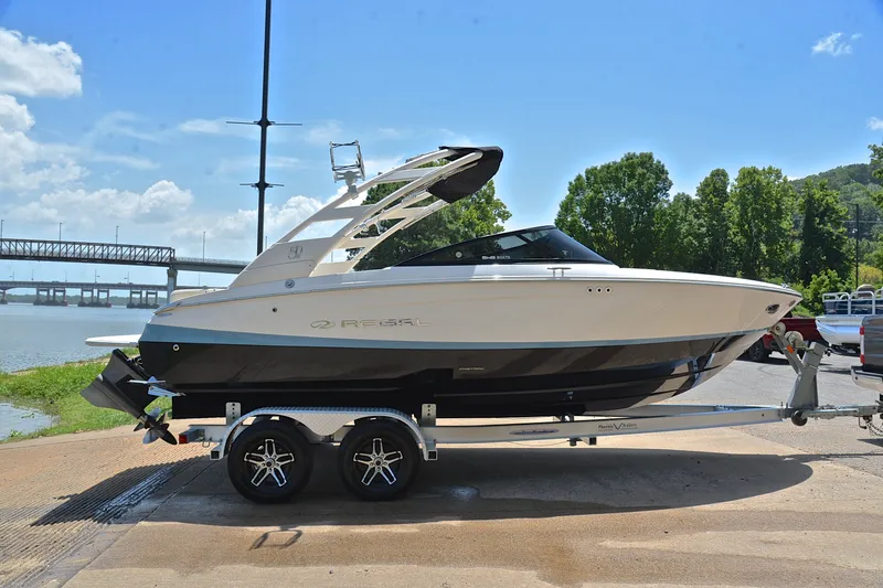 Slide: The Image of 2020 Regal LS2 Surf boat on trailer by riverside, sunny day. - 16