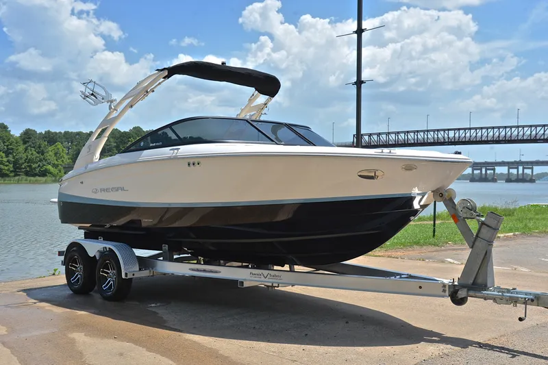 Slide: The Image of 2020 Regal LS2 Surf boat on trailer by a scenic river. - 17
