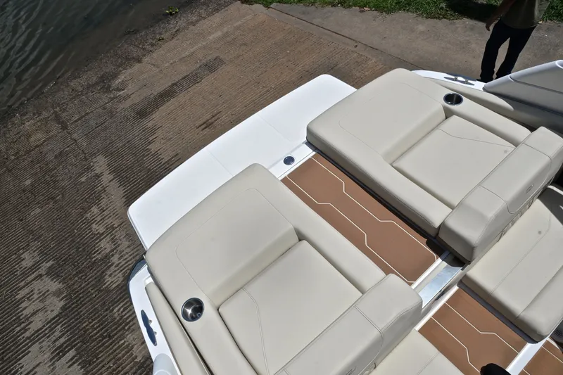 Slide: The Image of 2020 Regal LS2 Surf boat interior with beige seating and brown flooring near water. - 24