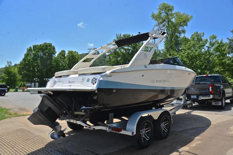 Slide: The Image of 2020 Regal LS2 Surf boat on trailer, parked outdoors on a sunny day. - 15