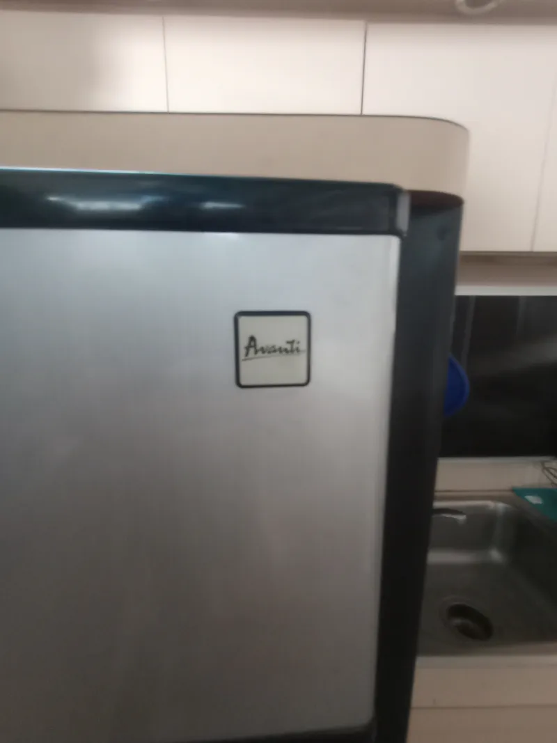 Slide: The Image of An Avanti refrigerator in a boat galley with a sink and cabinets. - 26
