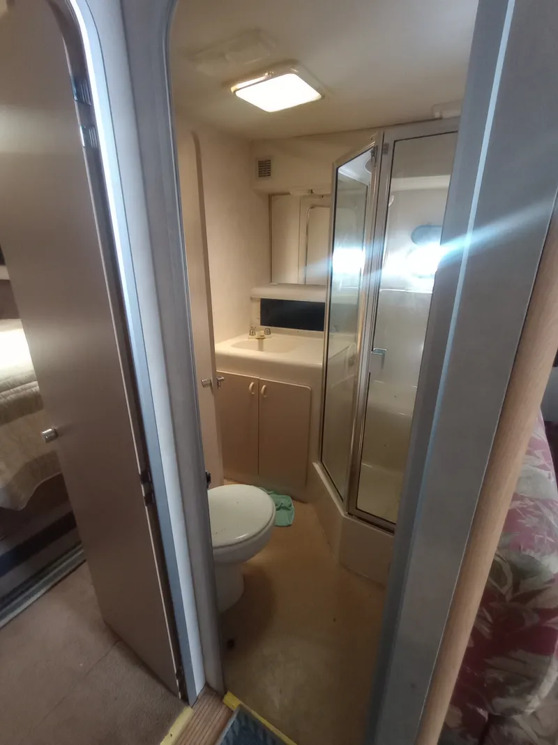 Slide: The Image of The image shows the bathroom of a 1991 Silverton AFT CABIN with a shower and toilet. - 27