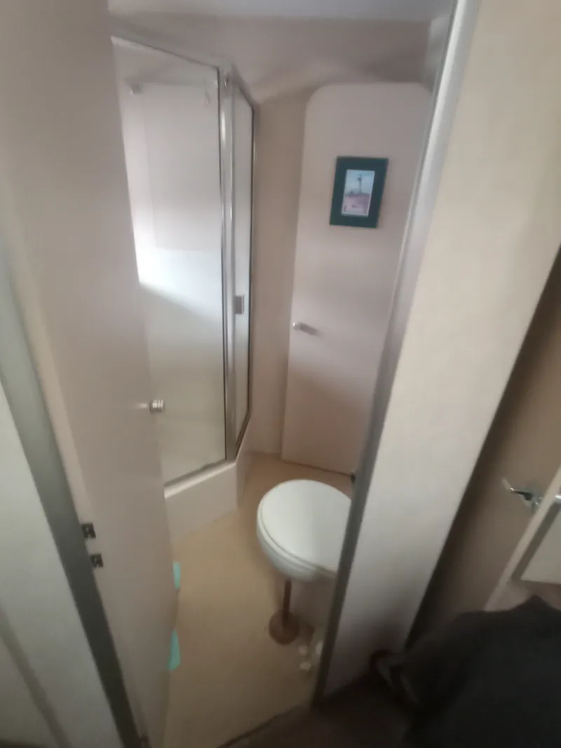 Slide: The Image of The image shows a bathroom in a 1991 Silverton AFT CABIN with a shower and toilet. - 29