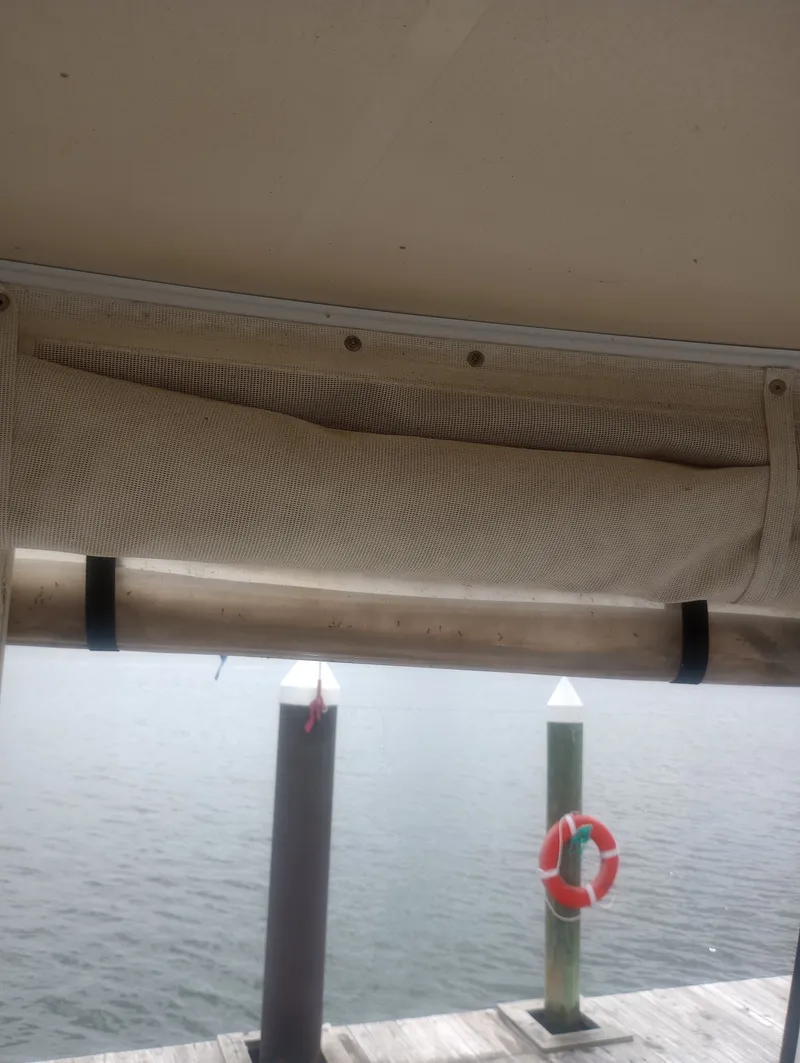 Slide: The Image of A boat canopy with a rolled-up sunshade, moored at a dock. - 12