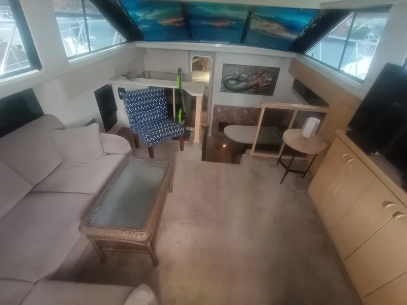 Slide: The Image of Interior of a 1991 Silverton AFT CABIN with sofa, table, and chairs. - 20