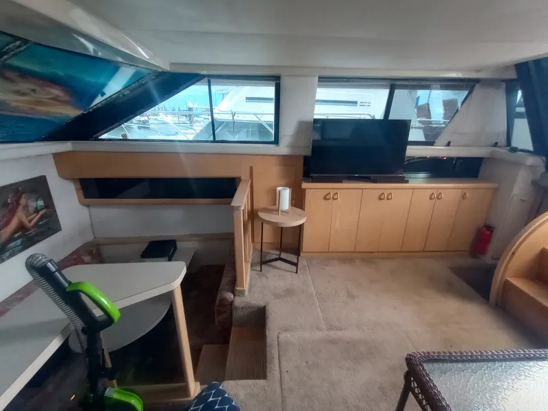 Slide: The Image of Interior of a 1991 Silverton AFT CABIN with carpeted floor, TV, and wooden cabinetry. - 24