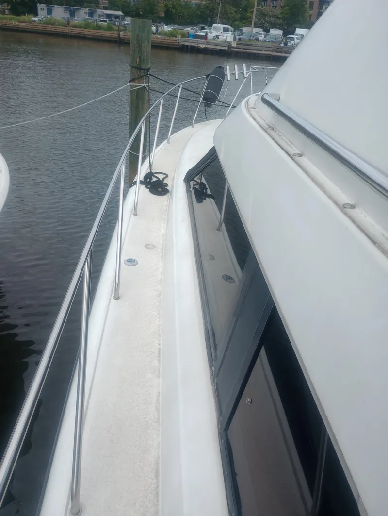 Slide: The Image of 1991 Silverton AFT CABIN by the water with railing and windows. - 4