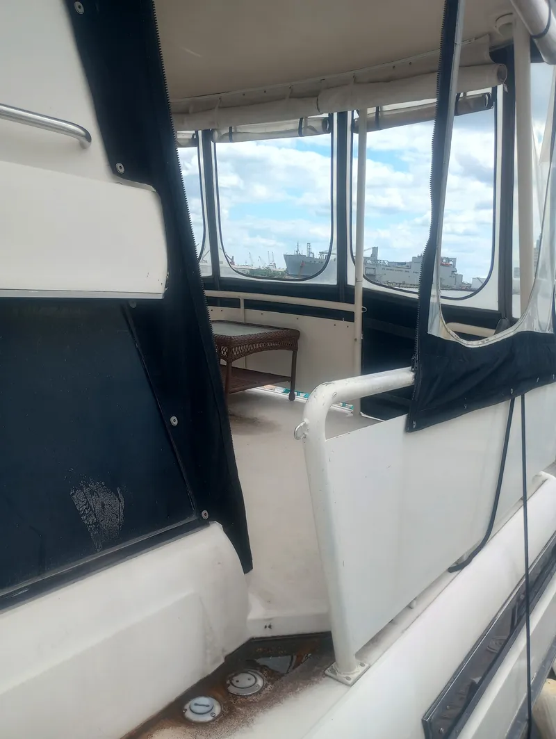 Slide: The Image of The image shows the aft deck of a 1991 Silverton AFT CABIN with seating area and windows. - 3