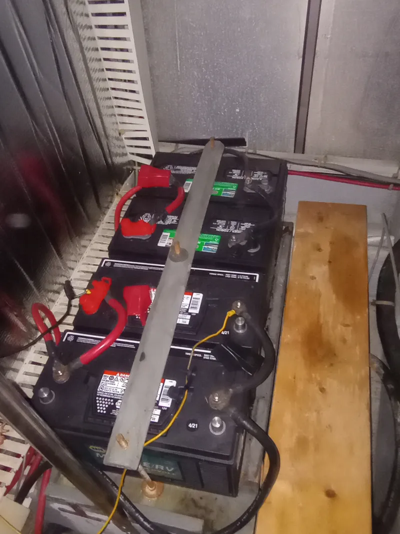 Slide: The Image of Three large batteries are secured in a tight space with cables and a metal bar. - 42