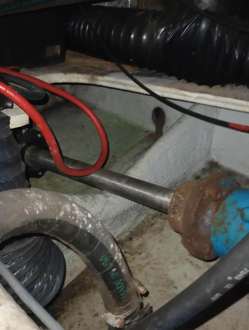 Slide: The Image of Close-up of a boat engine room with hoses and metal parts showing the drive shaft. - 49