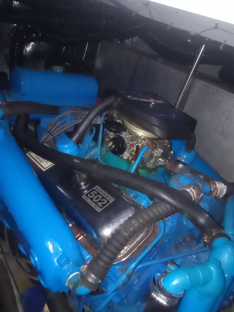 Slide: The Image of An engine compartment with a blue engine block and black covers, surrounded by hoses. - 43