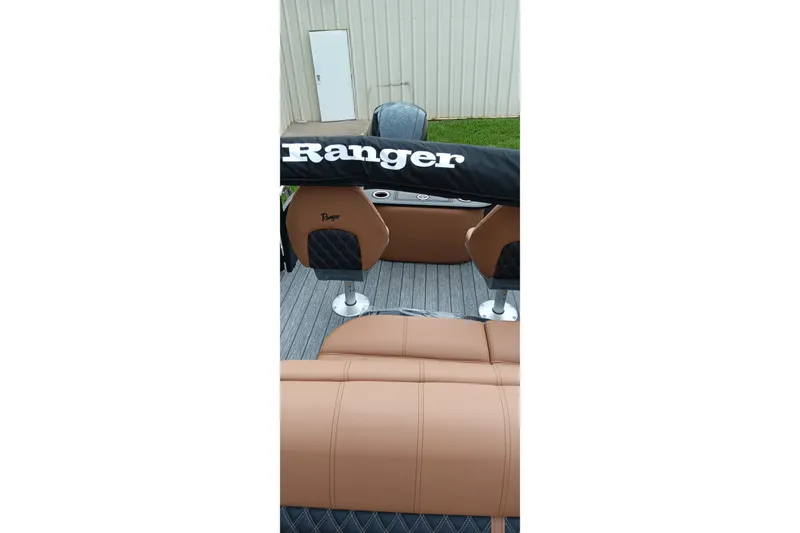 Slide: The Image of 2026 Ranger 220F boat interior with tan leather seats and branded cover. - 29