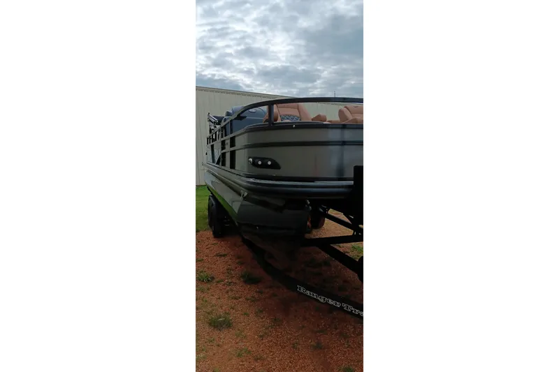 Slide: The Image of 2026 Ranger 220F boat on trailer, parked outdoors under cloudy sky. - 22
