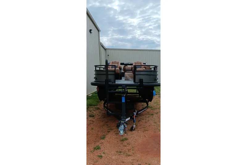 Slide: The Image of 2026 Ranger 220F boat on trailer, parked outdoors near metal building. - 21